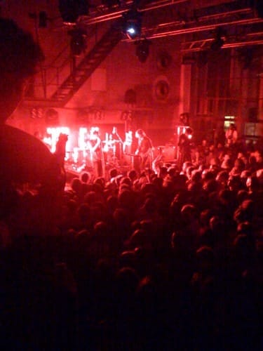 Une foule de personnes profitant de la vie nocturne de Berlin lors d'un concert gay dans une pièce sombre.