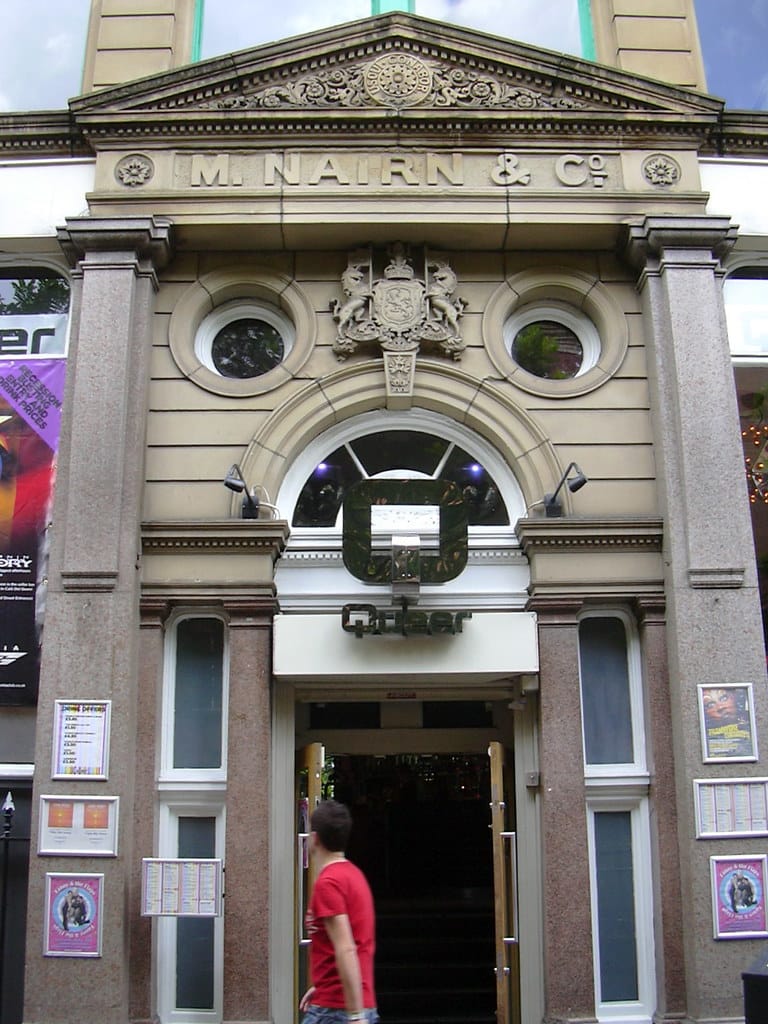 Un homme marchant à l'extérieur d'un bâtiment sur Canal Street à Manchester, embrassant la fierté LGBTQ+.