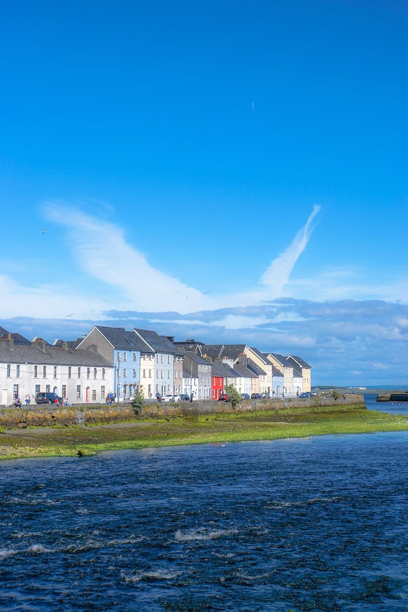 White and Brown Houses Near Green Grass Field Under Blue Sky