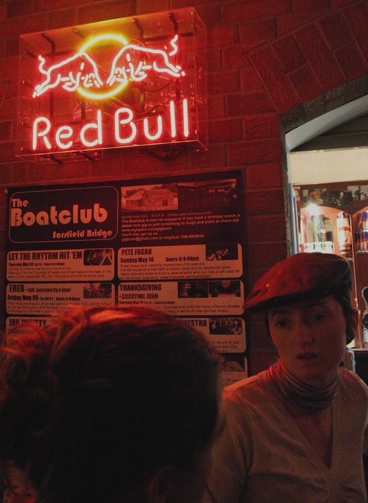 Une femme se tient devant un panneau Red Bull à Limerick.