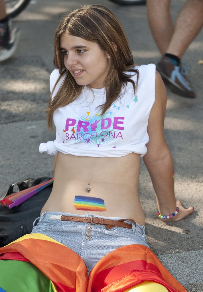 Une femme arborant fièrement un drapeau arc-en-ciel à Barcelone.