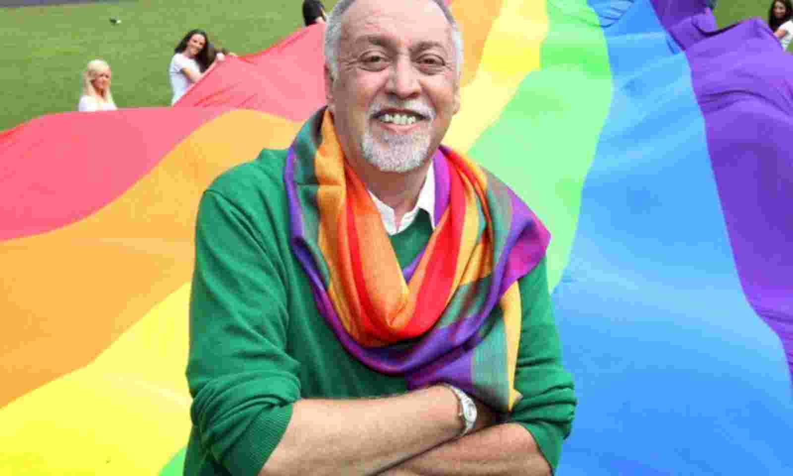 Un homme avec un drapeau arc-en-ciel.