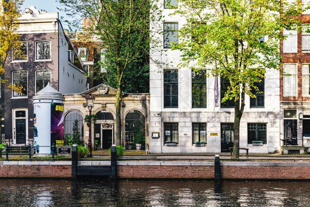 Une rangée de bâtiments sur un canal à Amsterdam gay-friendly.
Remarque : "Guide de voyage" signifie guide de voyage en français et n'est pas applicable dans ce contexte.