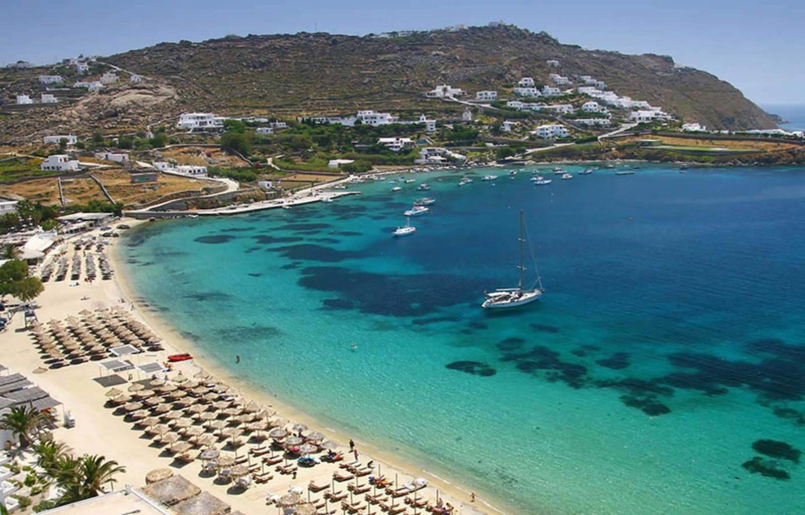 Une vue aérienne d'une plage avec des chaises et des bateaux en Europe.