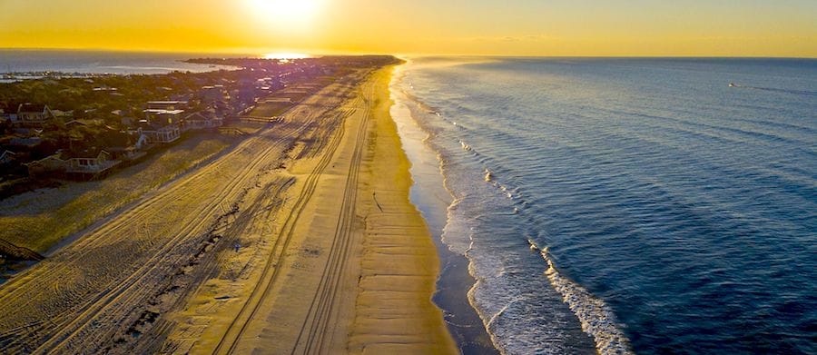 Une vue aérienne d'une plage gay en Europe au coucher du soleil.