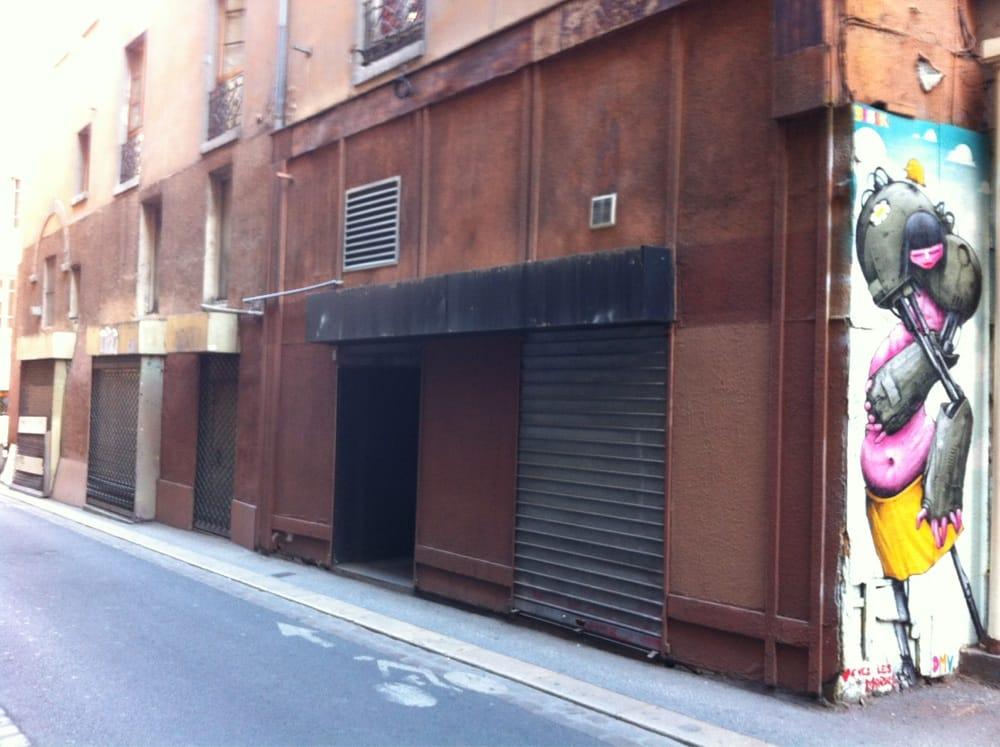 Une peinture murale embellissant un bâtiment dans la scène de rue animée de Lyon.