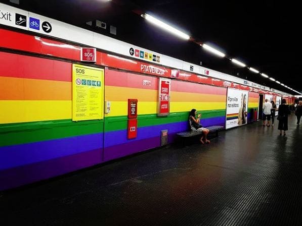 Une station de métro avec un mur arc-en-ciel.
