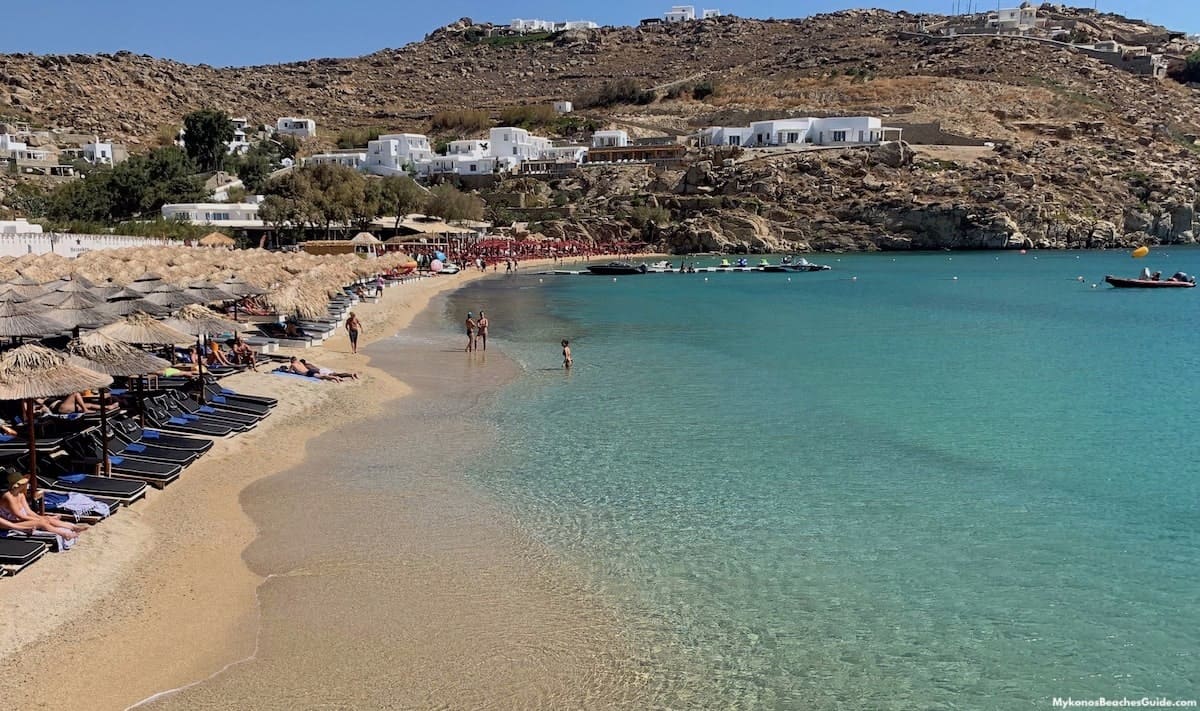 Une plage gay-friendly en Europe avec des chaises longues et des parasols au bord de l'eau.