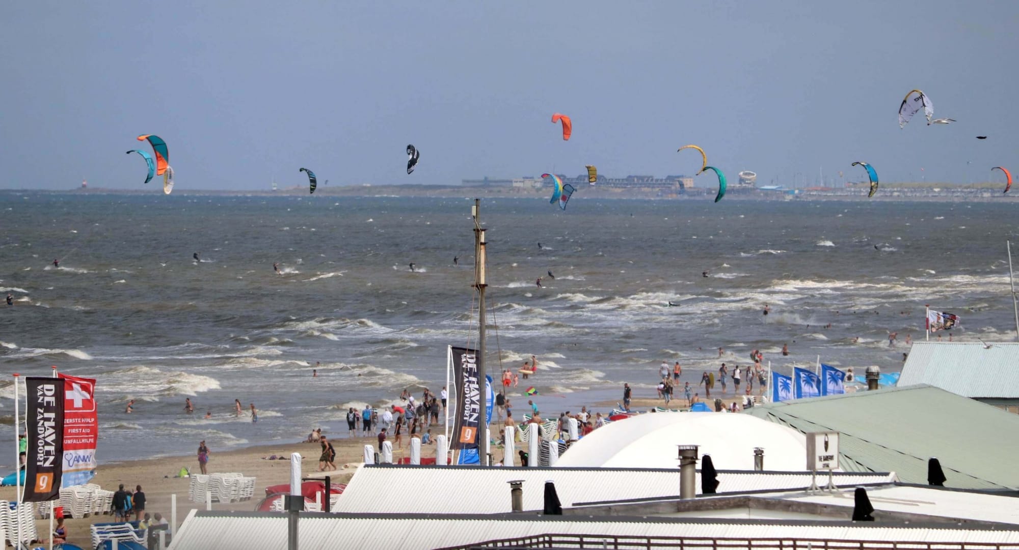Un groupe de personnes faisant voler des cerfs-volants sur la plage gay-friendly d'Amsterdam.