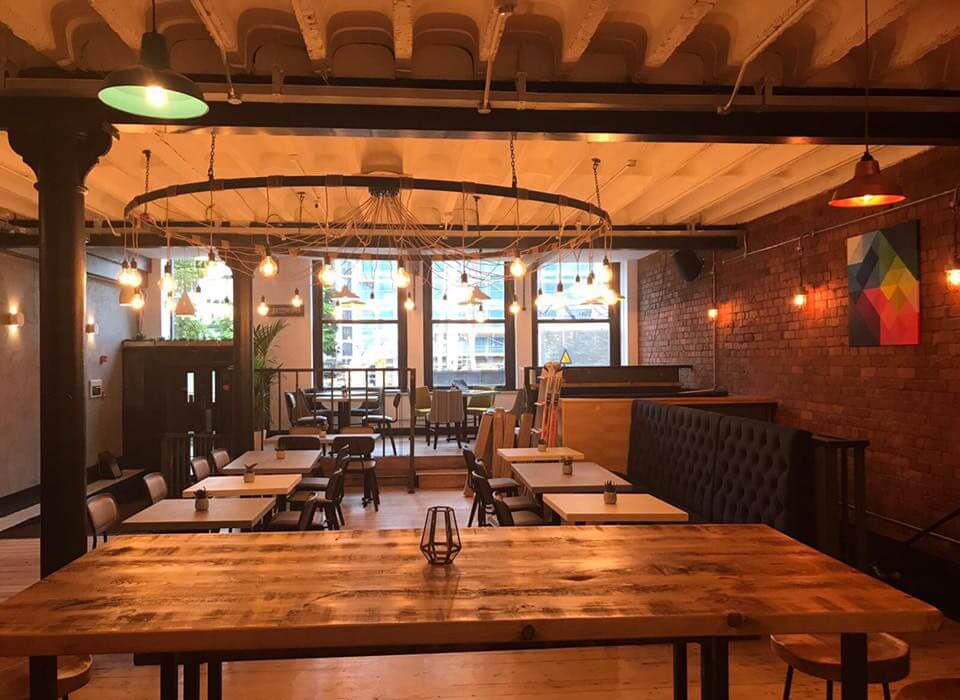 L'intérieur d'un restaurant avec tables et chaises en bois à Manchester.