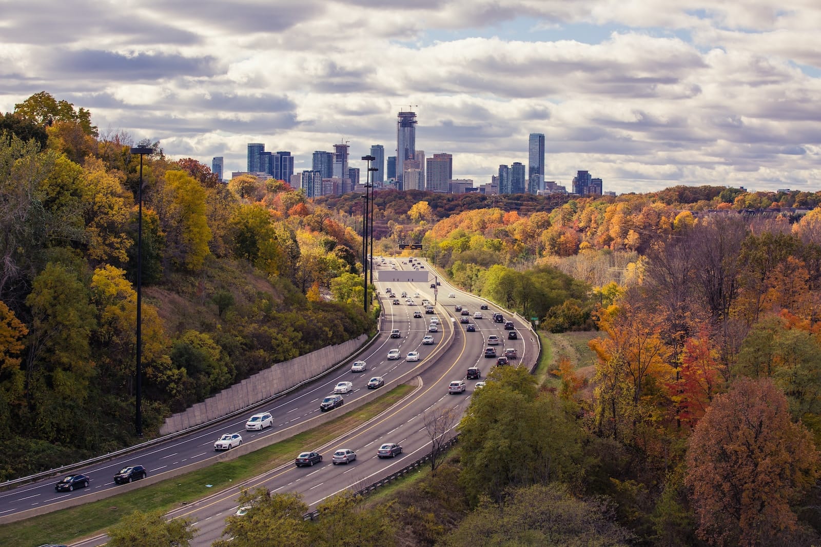 aerial photography of passing vehicles on highway leading to city